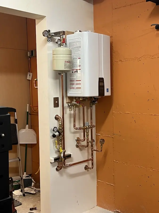 Plumbing technician inspecting water heater connections in Town of Pecos